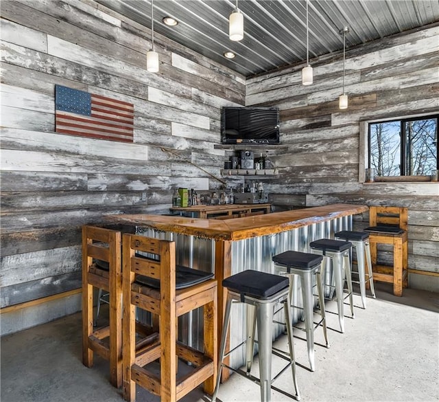 bar featuring concrete floors and wood counters