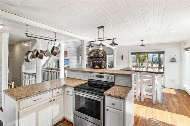 kitchen featuring a fireplace, wood ceiling, electric range, light hardwood / wood-style flooring, and white cabinets