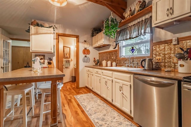 kitchen featuring dishwasher, backsplash, light hardwood / wood-style floors, and sink