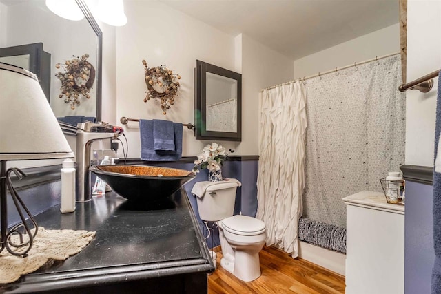 bathroom featuring curtained shower, sink, toilet, and hardwood / wood-style flooring