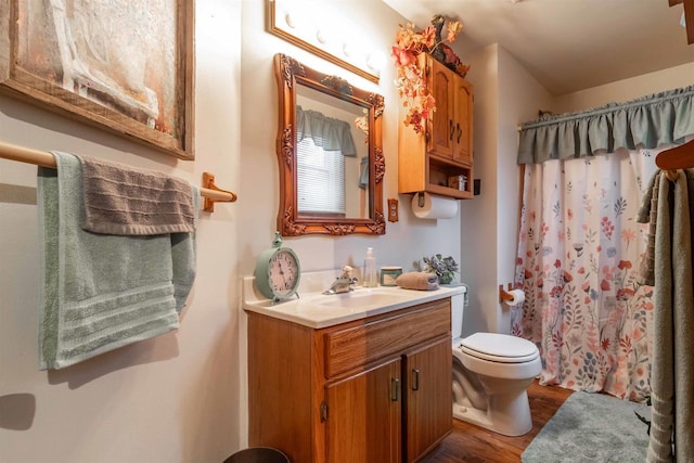 bathroom featuring wood-type flooring, vanity, toilet, and a shower with curtain