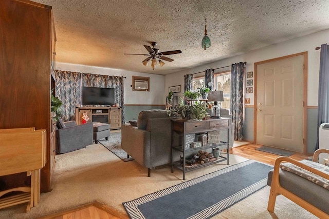 living room with ceiling fan and a textured ceiling