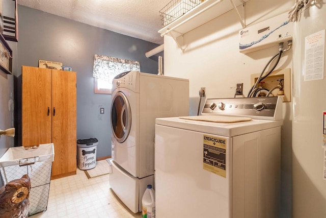 clothes washing area with separate washer and dryer, a textured ceiling, and water heater