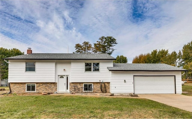 bi-level home featuring a garage and a front lawn