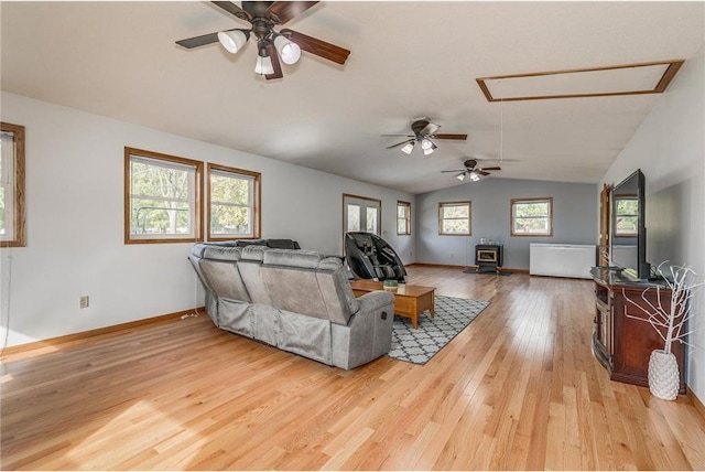 living room with a wealth of natural light, ceiling fan, light hardwood / wood-style floors, and vaulted ceiling