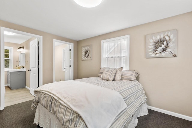 bedroom featuring connected bathroom and carpet floors