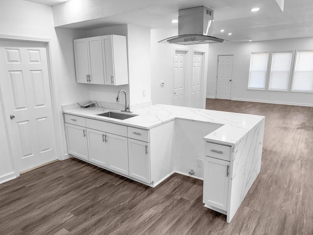 kitchen featuring island exhaust hood, white cabinetry, sink, and light stone counters