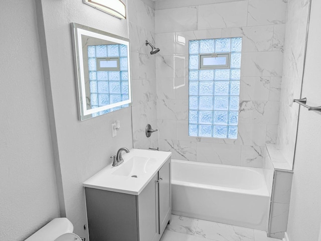 full bathroom featuring vanity, tiled shower / bath combo, and toilet