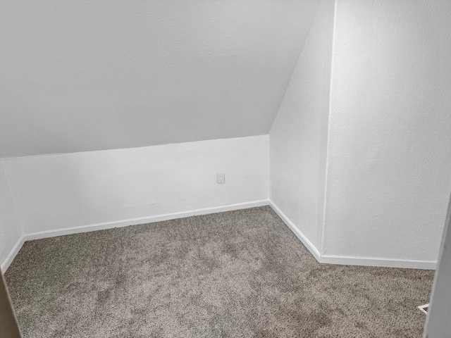 bonus room with carpet floors and vaulted ceiling