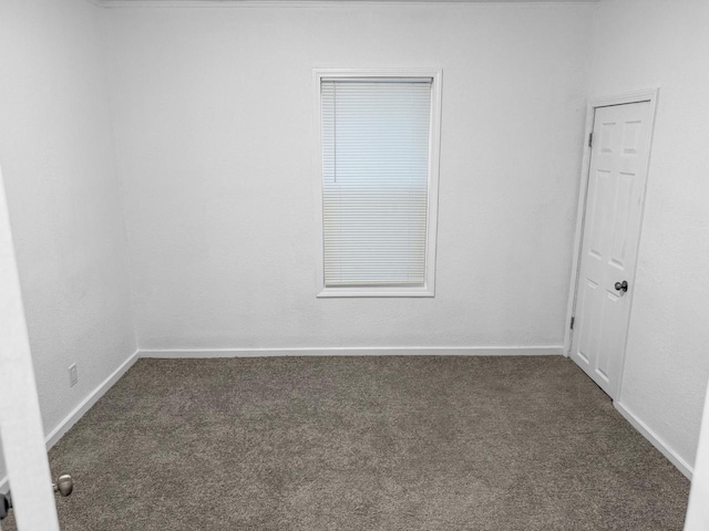 unfurnished room with dark colored carpet