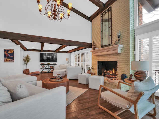 living room with beam ceiling, a brick fireplace, dark hardwood / wood-style floors, a notable chandelier, and a towering ceiling