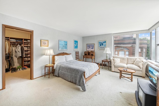 bedroom with carpet, a walk in closet, and a closet