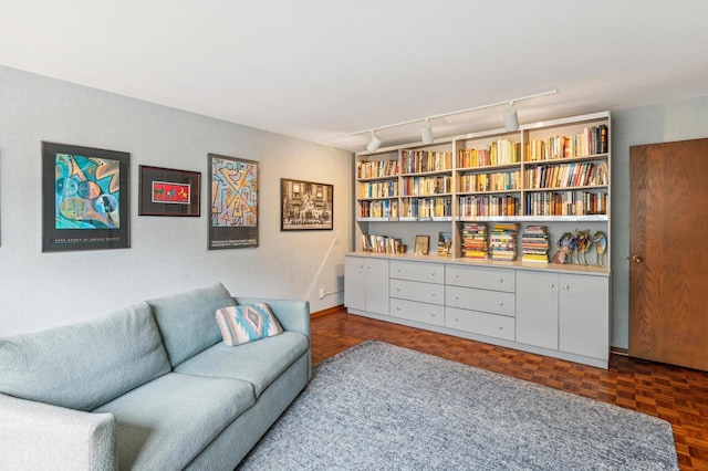 sitting room featuring dark parquet floors and rail lighting