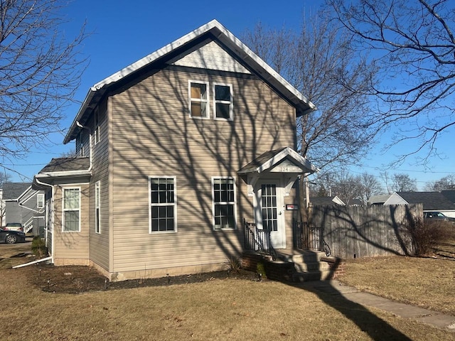 rear view of property featuring a lawn