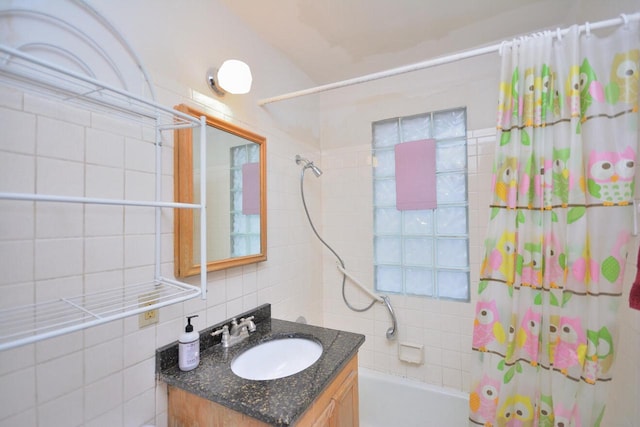 bathroom featuring vanity, shower / bathtub combination with curtain, and tile walls