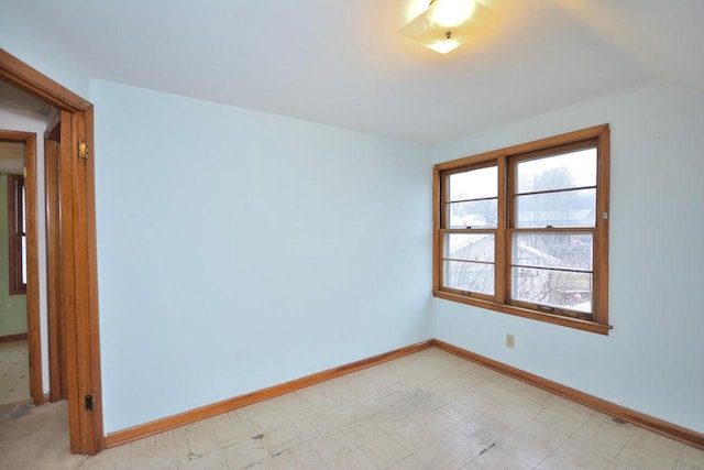 unfurnished room featuring vaulted ceiling