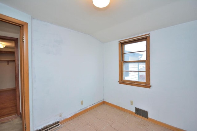 spare room featuring vaulted ceiling