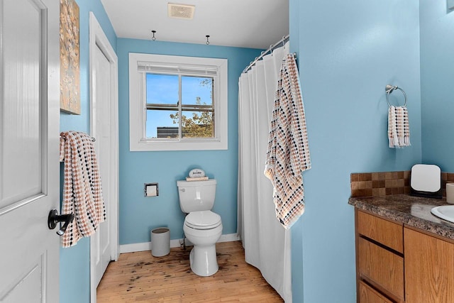 bathroom featuring wood-type flooring, vanity, and toilet