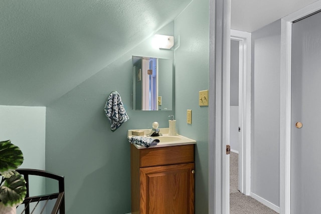 bathroom with vanity and lofted ceiling