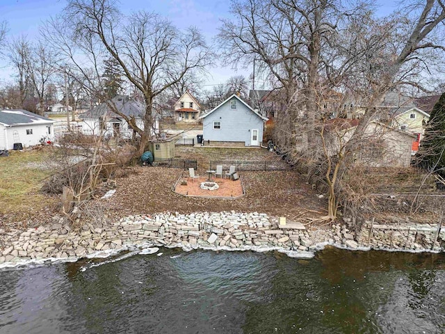 rear view of house featuring a fire pit and a water view