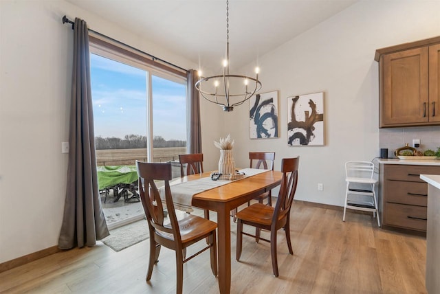 dining space featuring light wood-type flooring and a notable chandelier