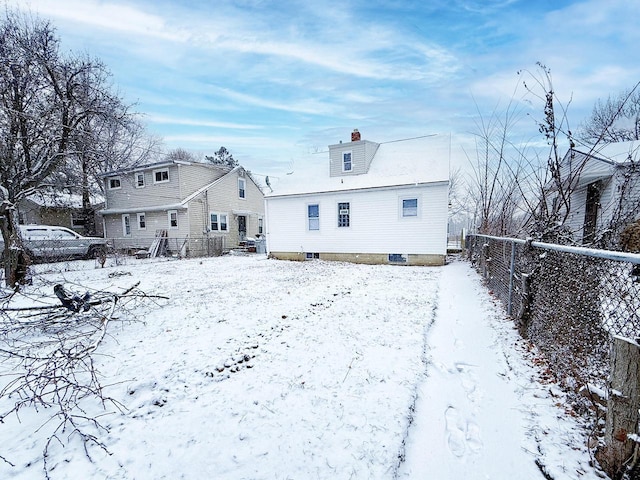 view of snow covered back of property