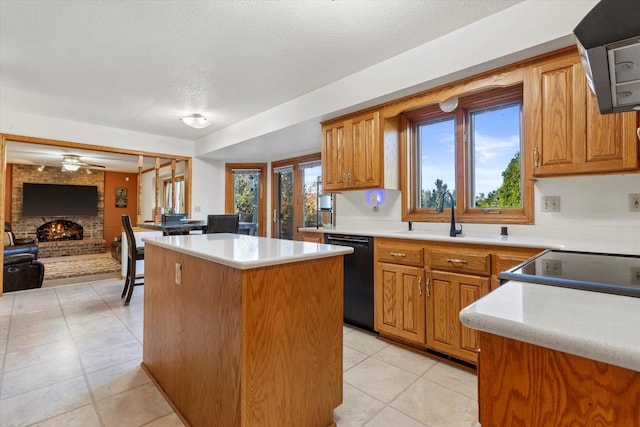 kitchen with dishwasher, a center island, a brick fireplace, and a healthy amount of sunlight