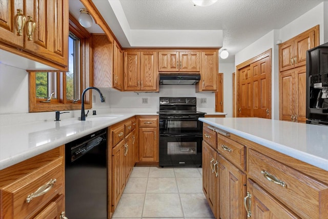 kitchen featuring black appliances, sink, light tile patterned floors, and a textured ceiling