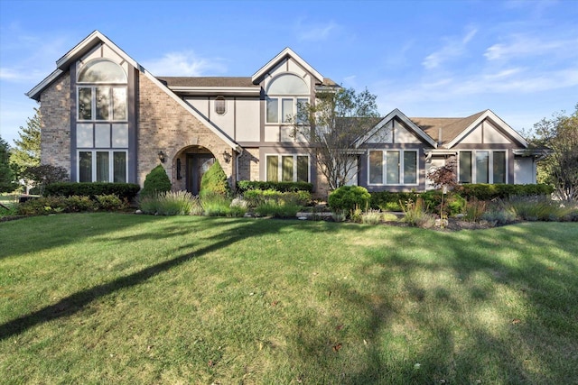 tudor-style house featuring a front yard