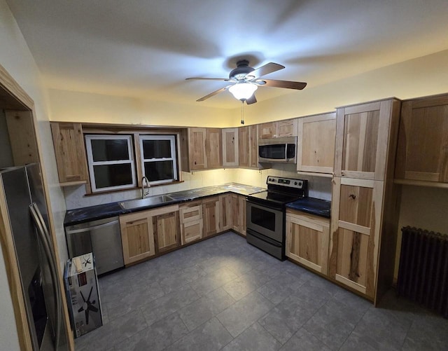 kitchen featuring sink, radiator, ceiling fan, and appliances with stainless steel finishes