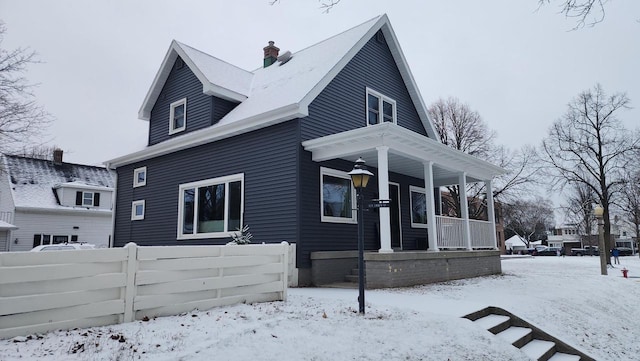 view of snow covered exterior featuring a porch