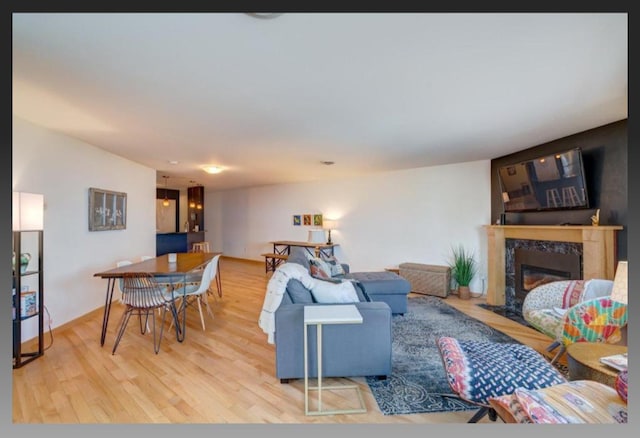 living room with wood-type flooring and a high end fireplace