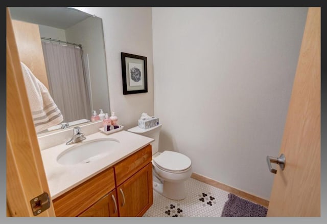 bathroom with vanity, toilet, and tile patterned flooring