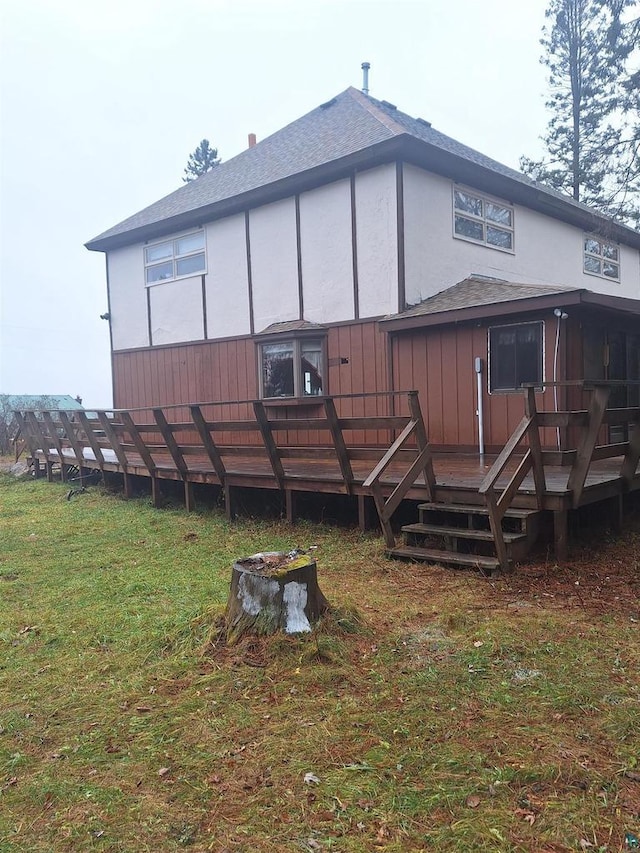 back of property featuring a yard and a wooden deck