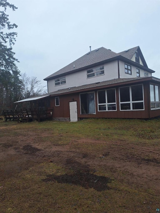 rear view of house featuring a sunroom