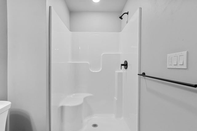 bathroom featuring a shower and toilet