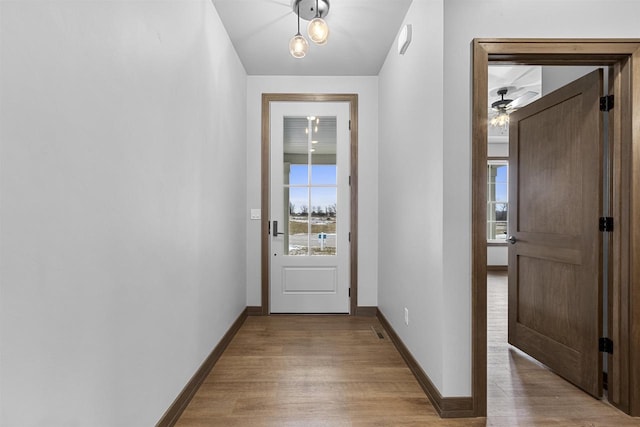 doorway with ceiling fan and light wood-type flooring