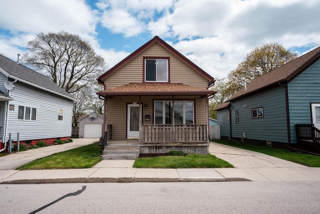 bungalow-style home with covered porch, a garage, and an outdoor structure