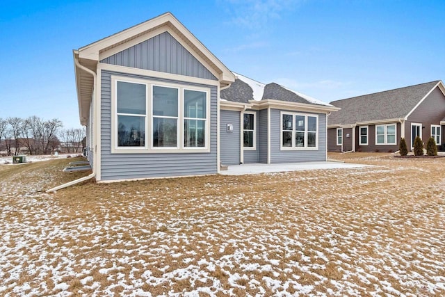 view of snow covered rear of property