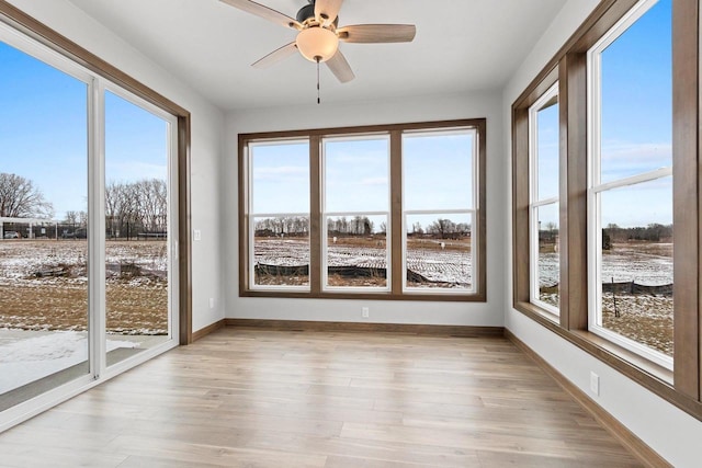 unfurnished sunroom with ceiling fan