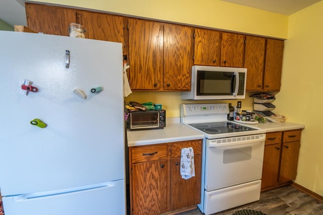 kitchen with dark hardwood / wood-style floors and white appliances