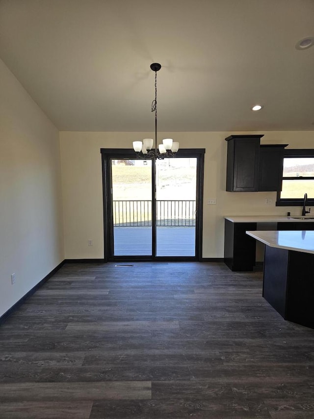 kitchen with pendant lighting, dark hardwood / wood-style flooring, sink, and an inviting chandelier