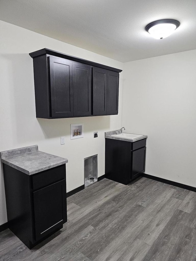 clothes washing area featuring cabinets, washer hookup, electric dryer hookup, sink, and wood-type flooring