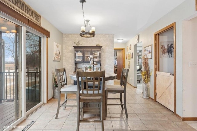 dining space featuring light tile patterned floors and an inviting chandelier