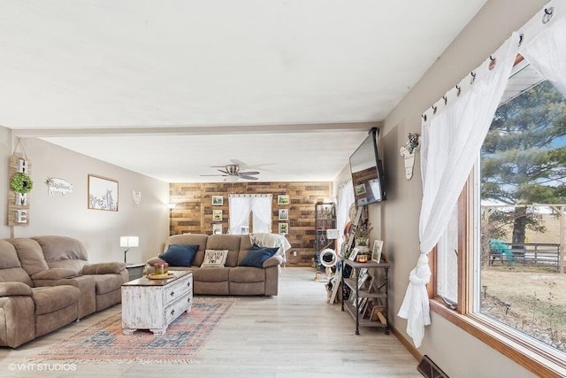 living room featuring ceiling fan, beam ceiling, and light hardwood / wood-style floors