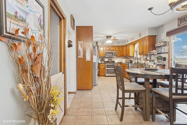 tiled dining room featuring ceiling fan and sink