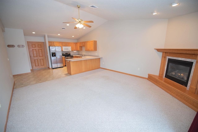 kitchen with kitchen peninsula, appliances with stainless steel finishes, light colored carpet, ceiling fan, and light brown cabinets