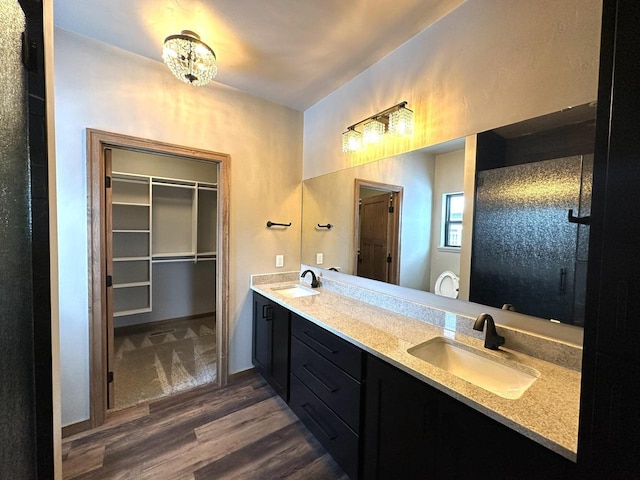 bathroom with wood-type flooring, vanity, and a notable chandelier