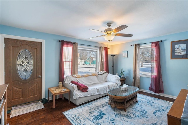 living room featuring ceiling fan and dark wood-type flooring