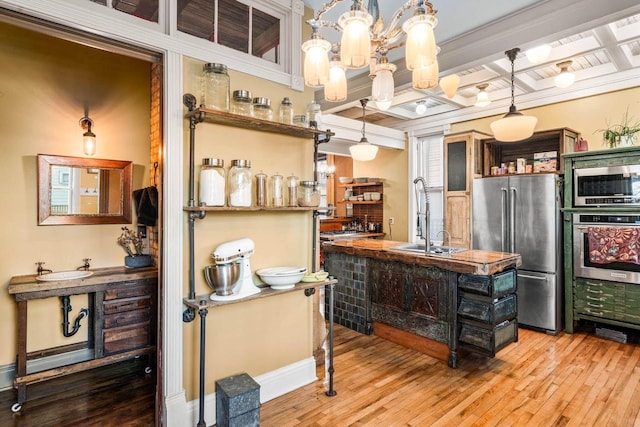 kitchen featuring sink, decorative light fixtures, beamed ceiling, coffered ceiling, and appliances with stainless steel finishes